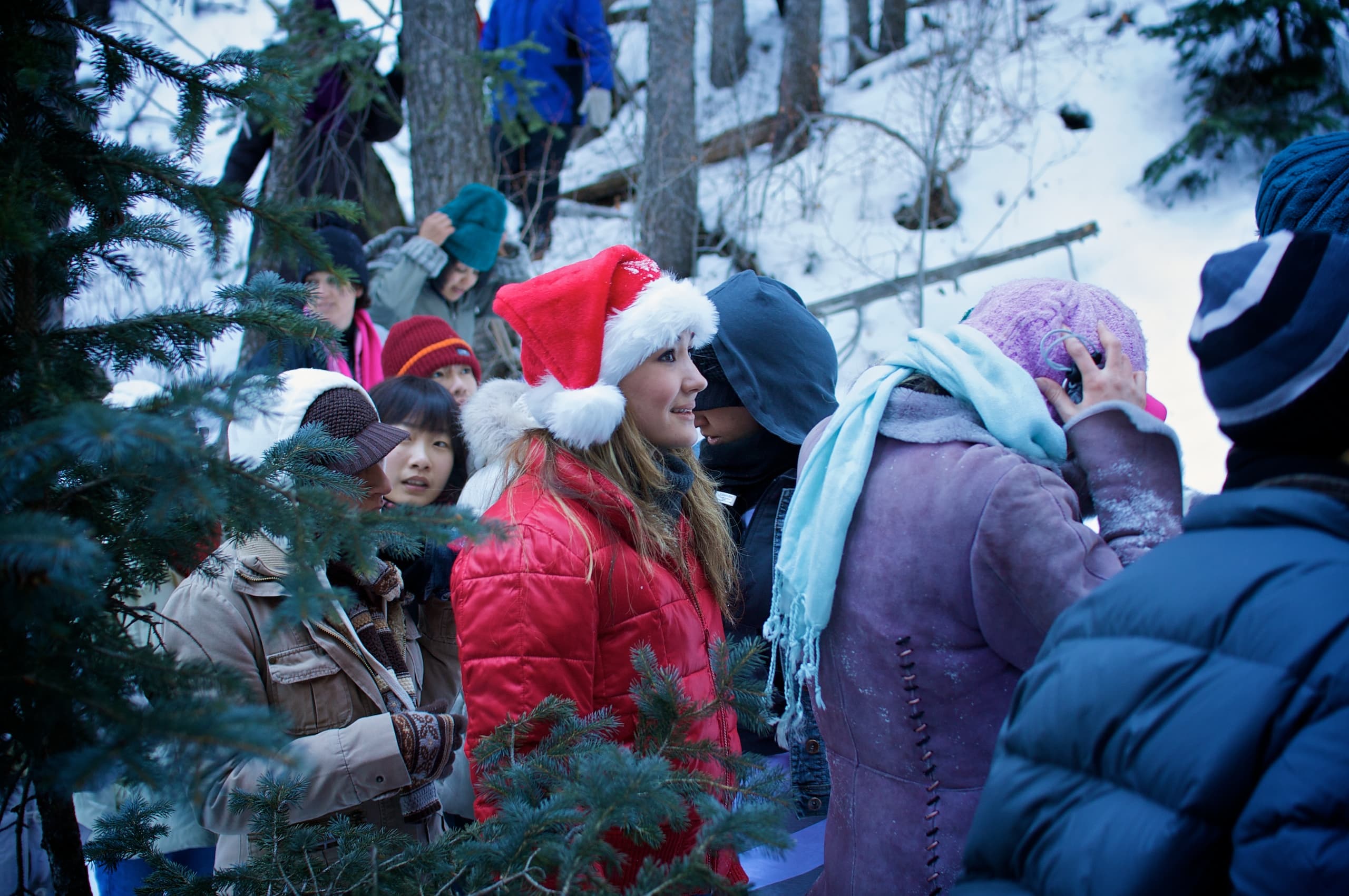 Children gathered outdoors in snow, including a child wearing a Santa hat